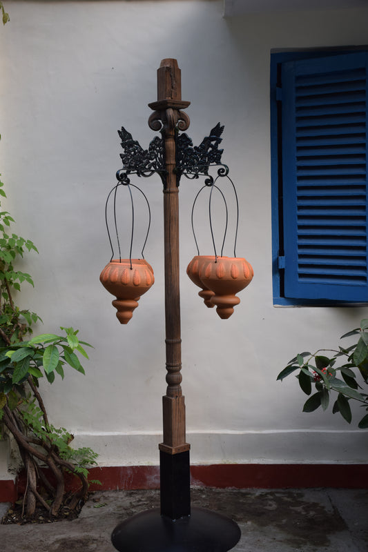 Free standing pillar with wooden planter at the base and brackets for hanging baskets