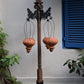 Free standing pillar with wooden planter at the base and brackets for hanging baskets
